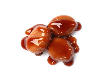 Photo of Tasty sweet candies and caramel sauce isolated on white, top view