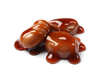 Photo of Tasty sweet candies and caramel sauce isolated on white