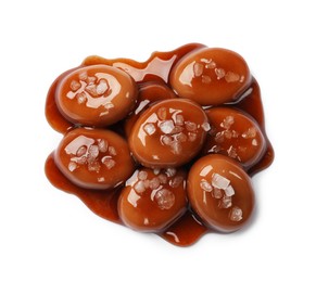Photo of Tasty sweet candies, salt and caramel sauce isolated on white, top view