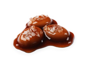 Photo of Tasty sweet candies, salt and caramel sauce isolated on white