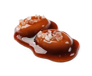 Photo of Tasty sweet candies, salt and caramel sauce isolated on white
