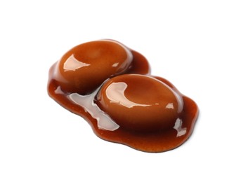 Photo of Tasty sweet candies and caramel sauce isolated on white