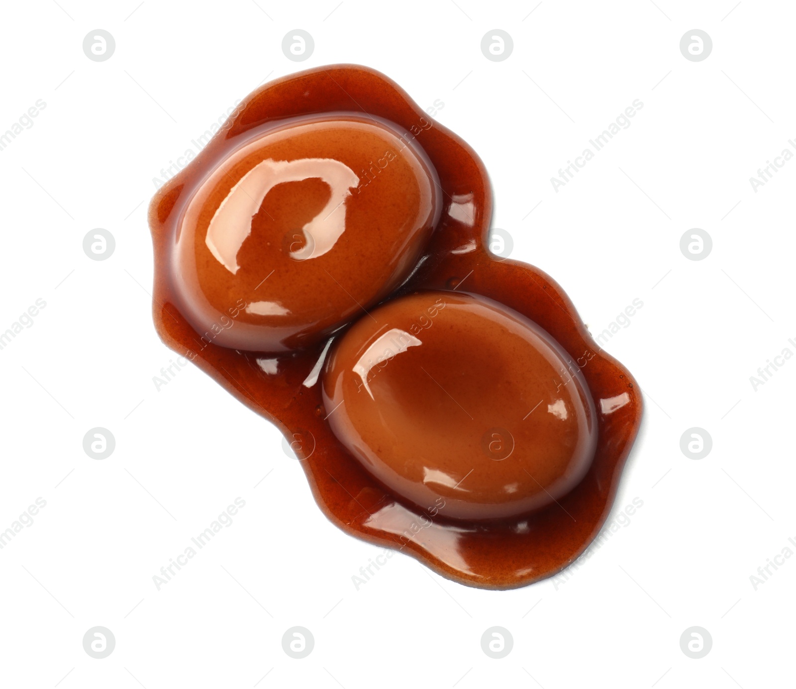 Photo of Tasty sweet candies and caramel sauce isolated on white, top view