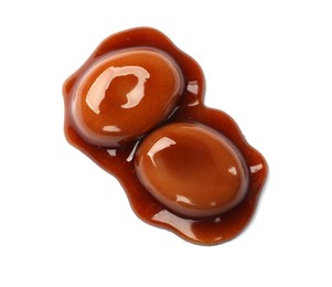 Photo of Tasty sweet candies and caramel sauce isolated on white, top view