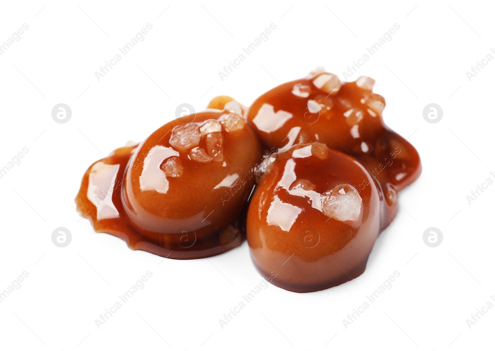 Photo of Tasty sweet candies, salt and caramel sauce isolated on white