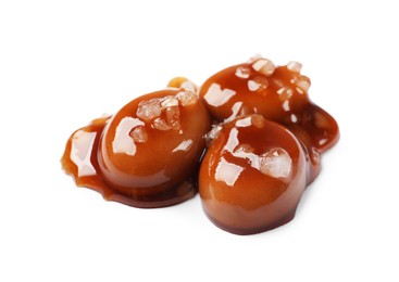 Photo of Tasty sweet candies, salt and caramel sauce isolated on white