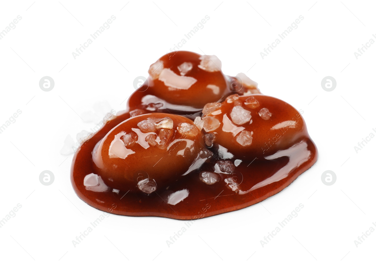 Photo of Tasty sweet candies, salt and caramel sauce isolated on white