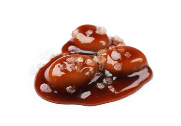 Photo of Tasty sweet candies, salt and caramel sauce isolated on white