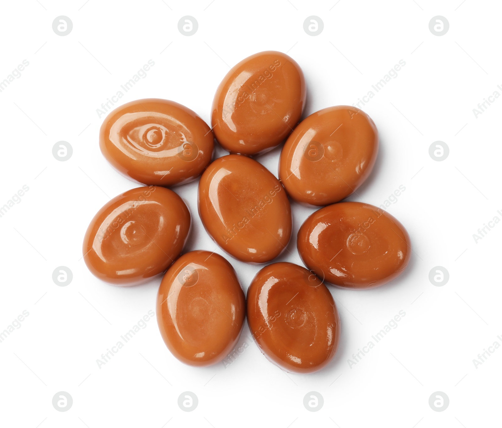 Photo of Tasty sweet caramel candies isolated on white, top view