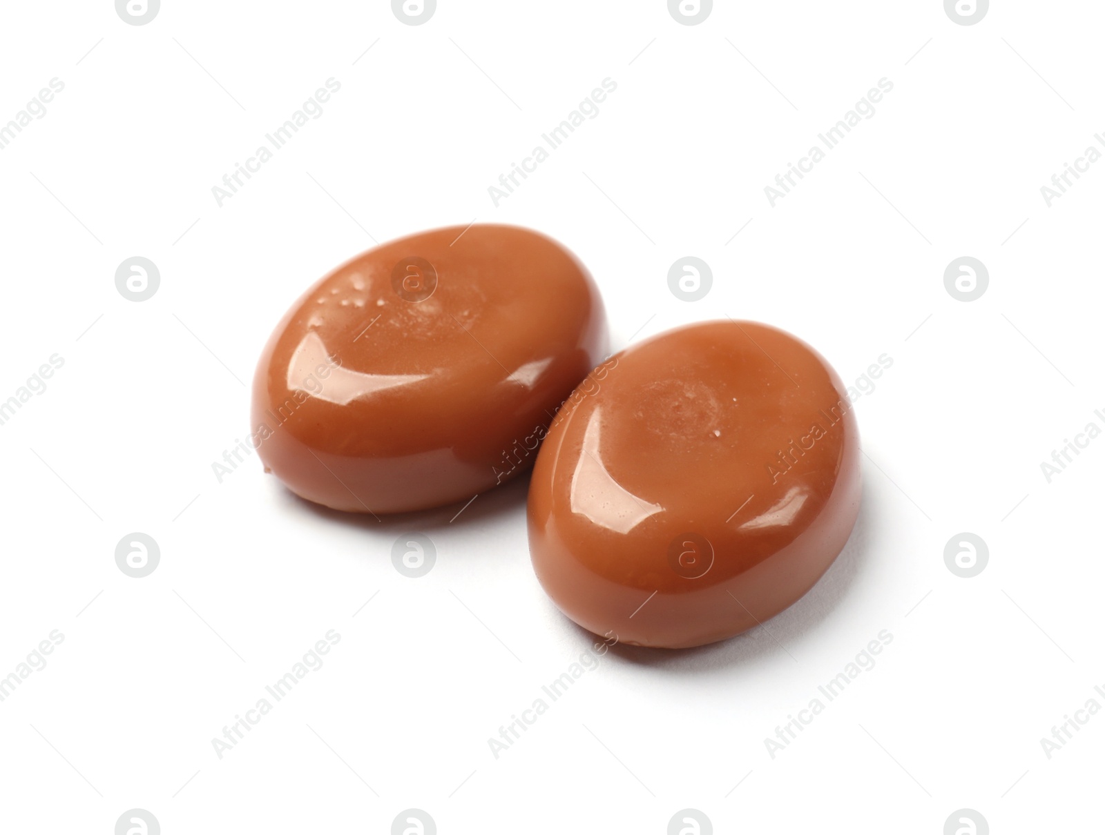 Photo of Tasty sweet caramel candies isolated on white
