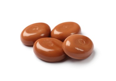 Photo of Tasty sweet caramel candies isolated on white