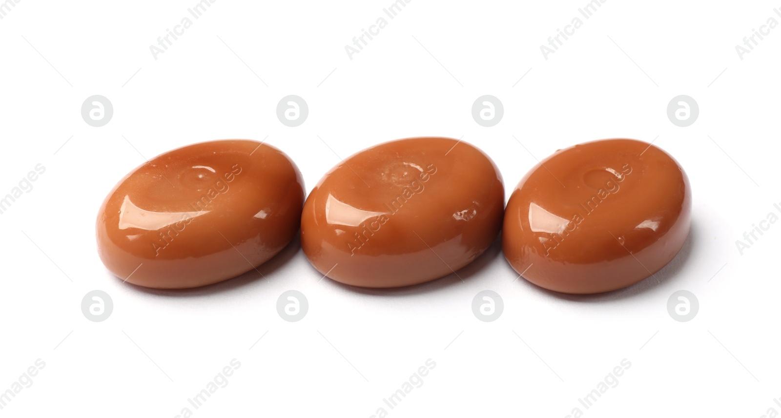 Tasty sweet caramel candies isolated on white Photo of Tasty sweet caramel candies isolated on white
