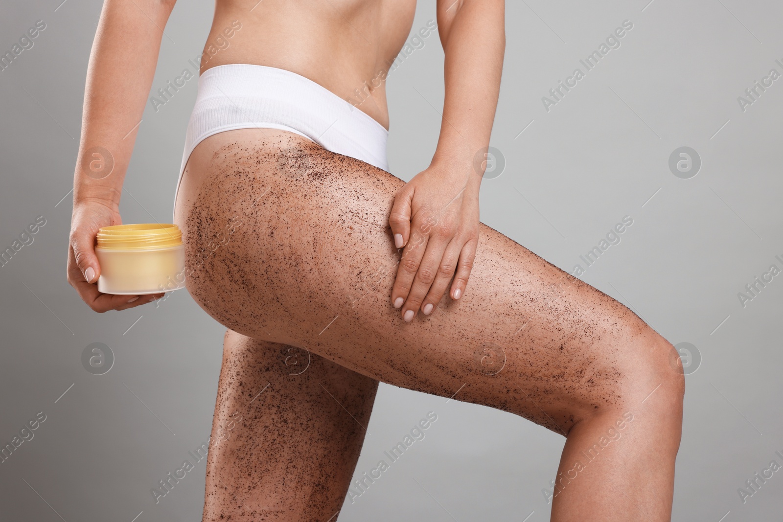 Woman with body scrub on her skin and jar against grey background, closeup Photo of Woman with body scrub on her skin and jar against grey background, closeup