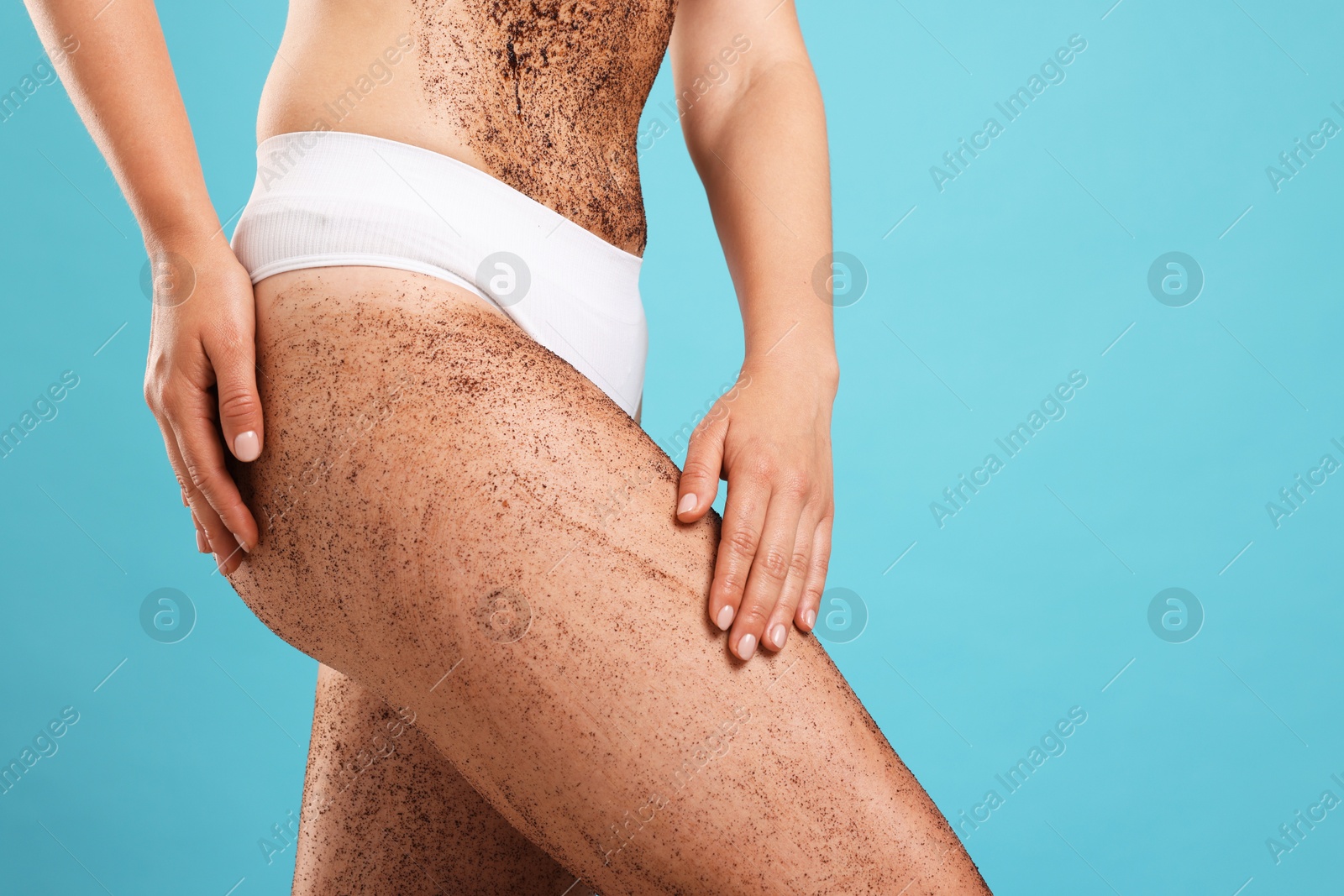 Woman with body scrub on her skin against light blue background, closeup. Space for text Photo of Woman with body scrub on her skin against light blue background, closeup. Space for text