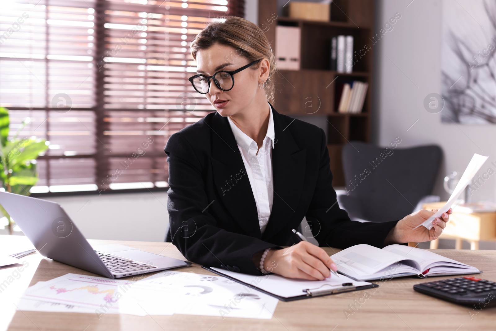 Professional banker working at desk in office Photo of Professional banker working at desk in office
