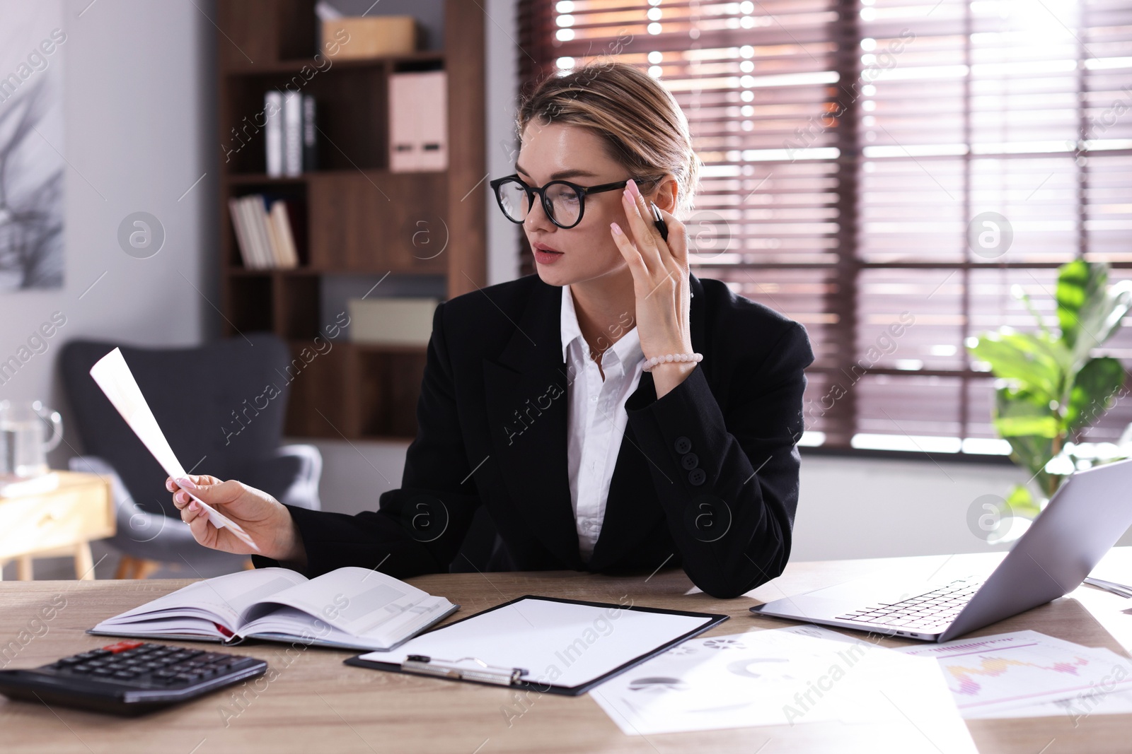 Professional banker working at desk in office Photo of Professional banker working at desk in office