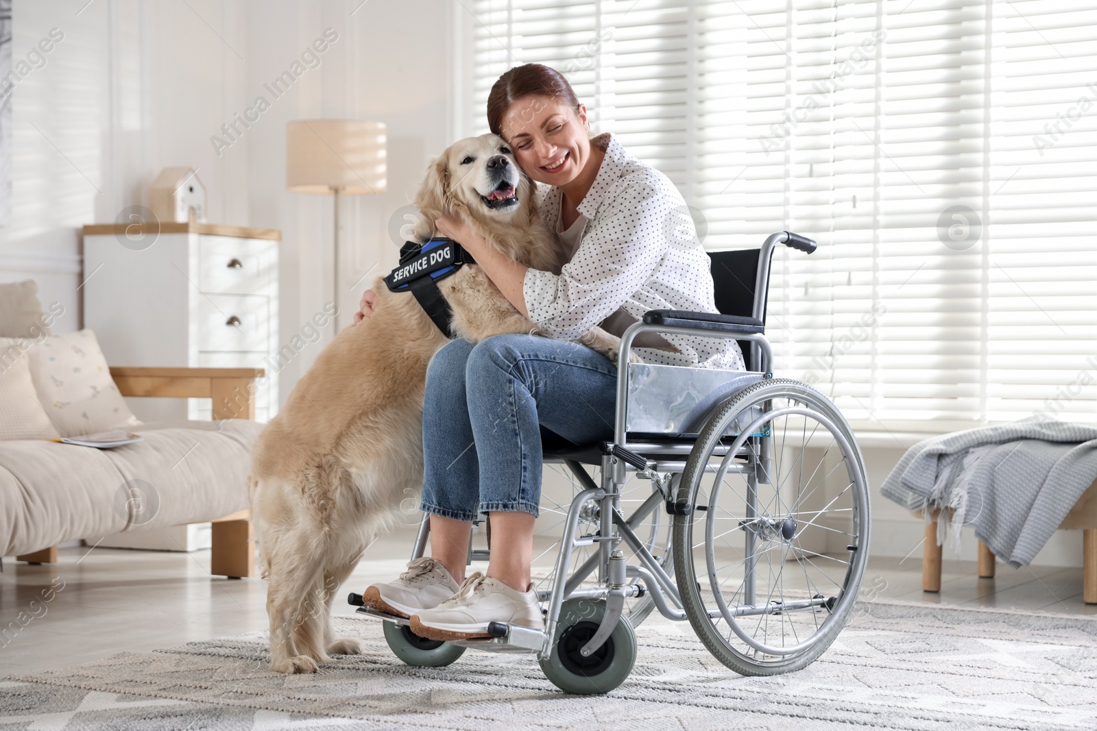 Photo of Woman in wheelchair hugging her service dog at home