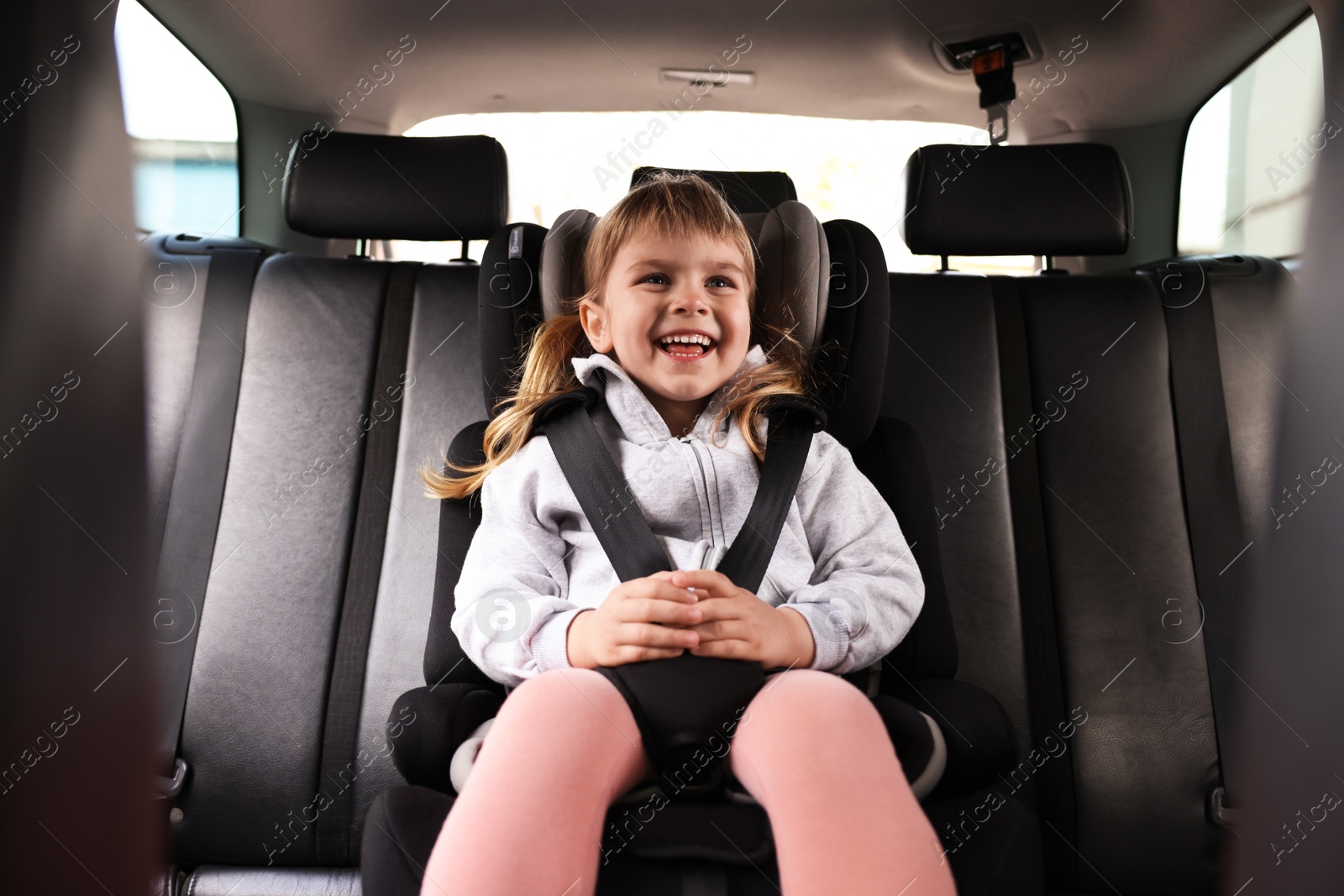 Little girl sitting in child safety seat inside car Photo of Little girl sitting in child safety seat inside car
