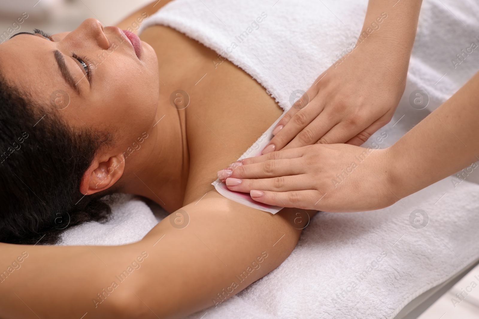 Woman undergoing wax epilation procedure in beauty salon Photo of Woman undergoing wax epilation procedure in beauty salon