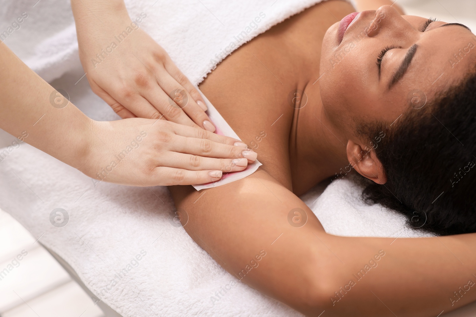 Woman undergoing wax epilation procedure in beauty salon Photo of Woman undergoing wax epilation procedure in beauty salon