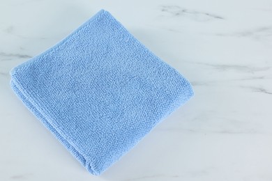 Photo of Clean towel on white marble table, above view