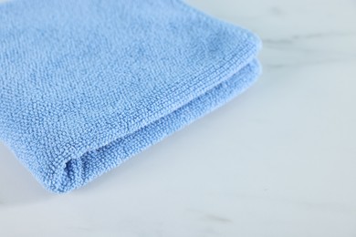 Photo of Clean towel on white marble table, closeup