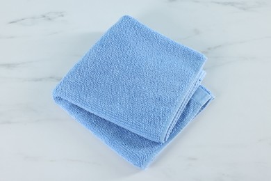 Photo of Clean towel on white marble table, above view