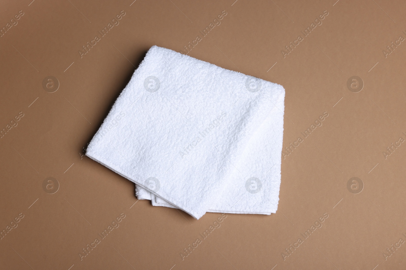 Clean towel on brown background, above view Photo of Clean towel on brown background, above view