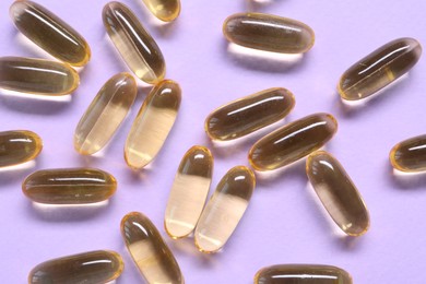 Photo of Collagen capsules on violet background, top view