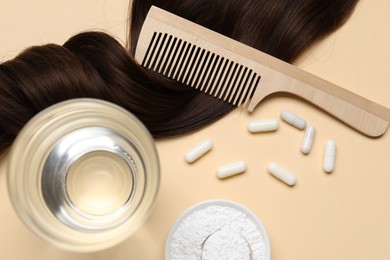 Photo of Collagen capsules, hair lock, powder, water and comb on beige background, flat lay