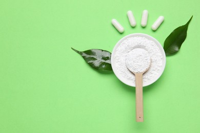 Photo of Flat lay composition with collagen capsules and powder on light green background. Space for text