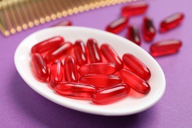 Photo of Collagen capsules and comb on purple background, closeup