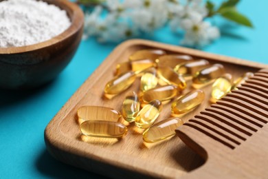 Photo of Collagen capsules, comb, powder and blossoms on light blue background, closeup