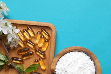 Photo of Collagen capsules, powder and blossoms on light blue background, flat lay. Space for text