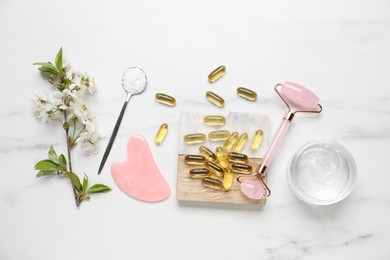 Photo of Flat lay composition with collagen capsules and blossoms on white marble table