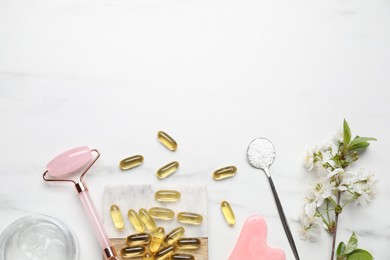 Photo of Flat lay composition with collagen capsules and blossoms on white marble table
