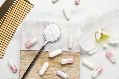 Photo of Collagen capsules, powder, comb and flower on white marble table, flat lay