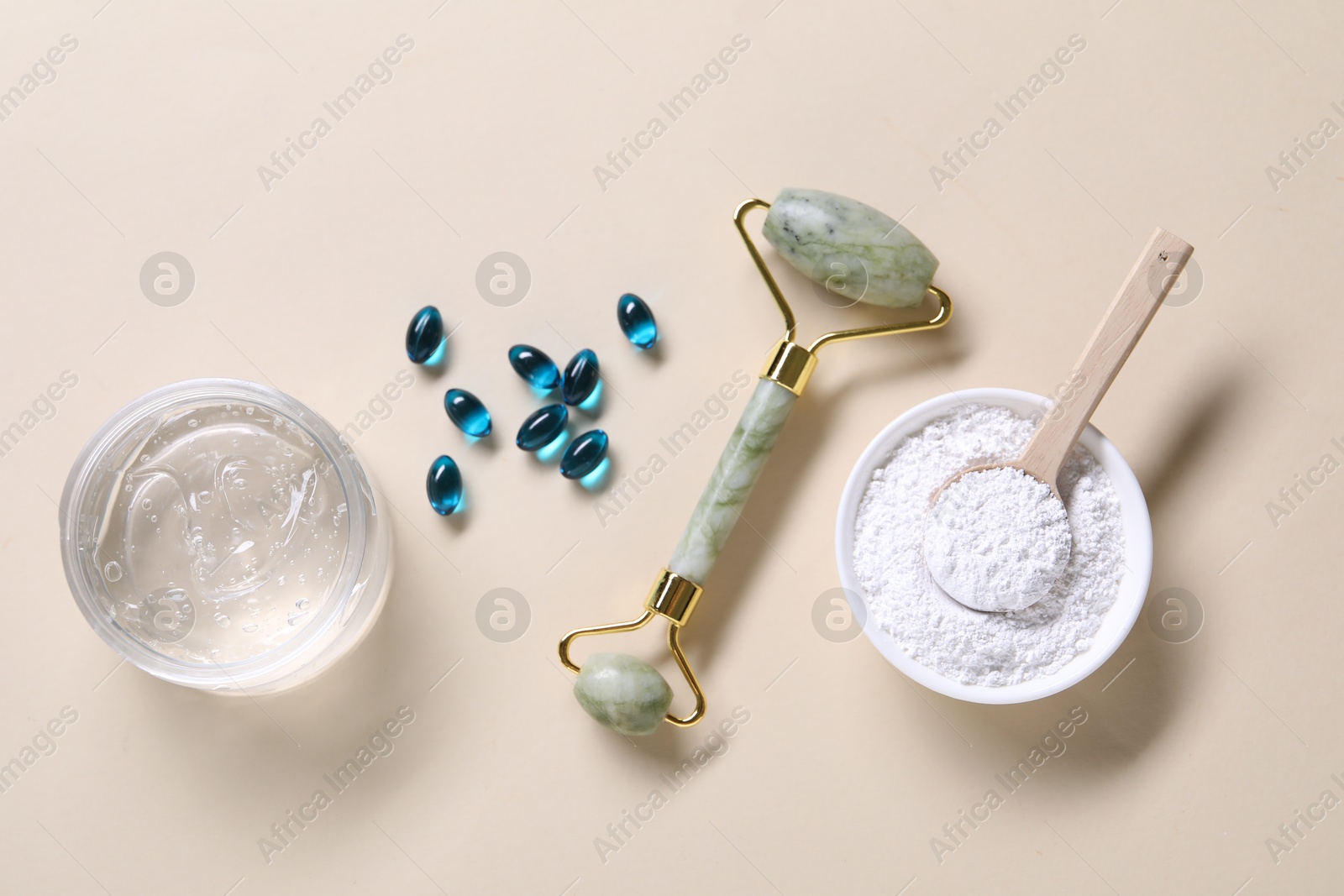 Collagen capsules, face roller, powder and gel on beige background, flat lay Photo of Collagen capsules, face roller, powder and gel on beige background, flat lay