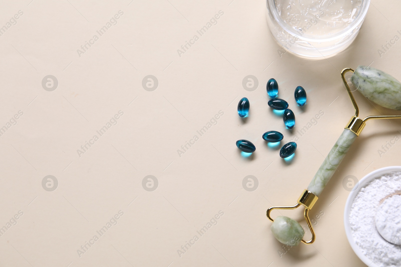 Collagen capsules, face roller, powder and gel on beige background, flat lay. Space for text Photo of Collagen capsules, face roller, powder and gel on beige background, flat lay. Space for text