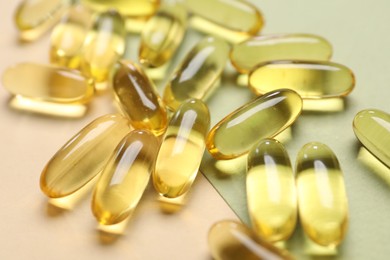 Photo of Many collagen capsules on color background, closeup