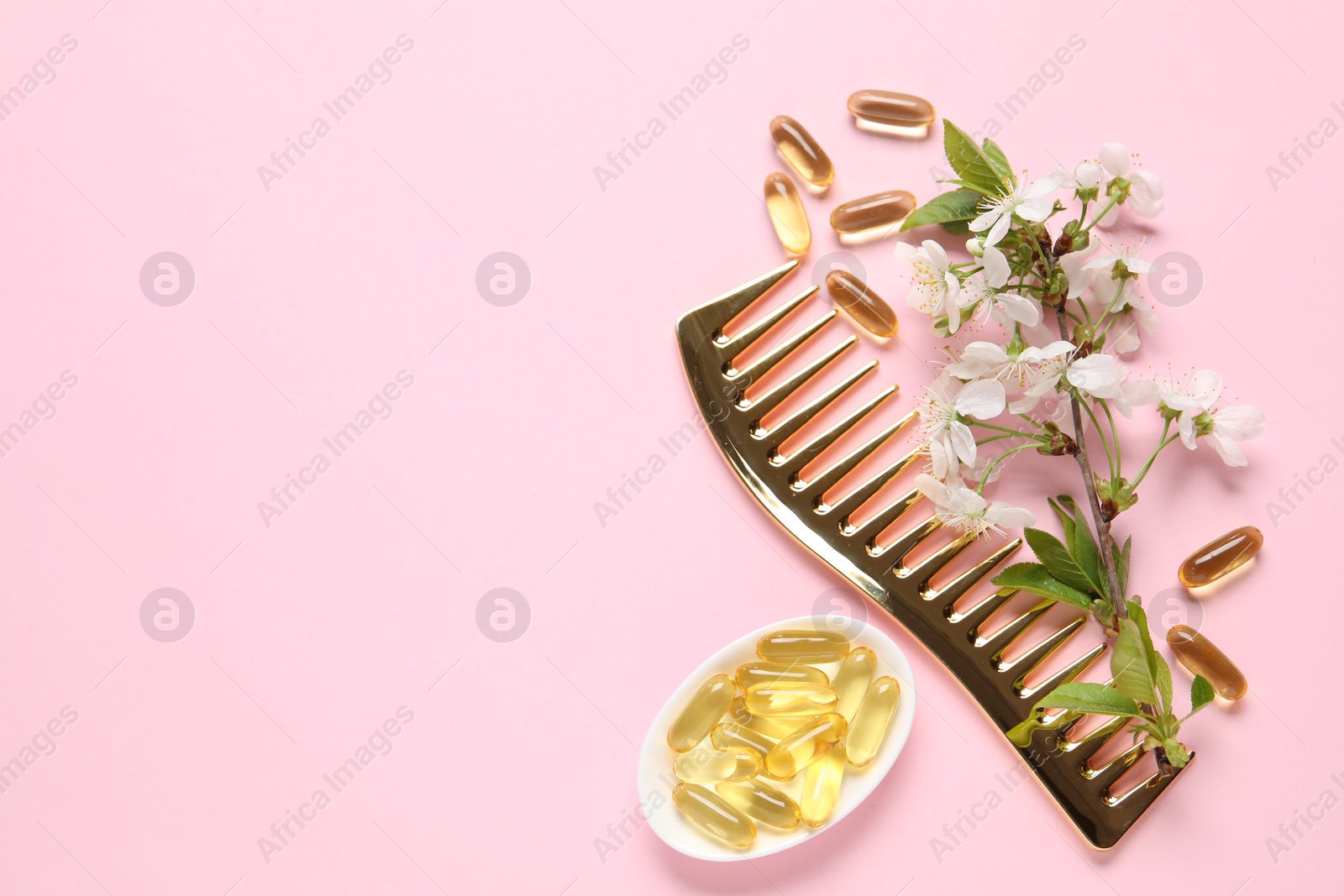 Collagen capsules, blossoms and comb on pink background, flat lay. Space for text Photo of Collagen capsules, blossoms and comb on pink background, flat lay. Space for text