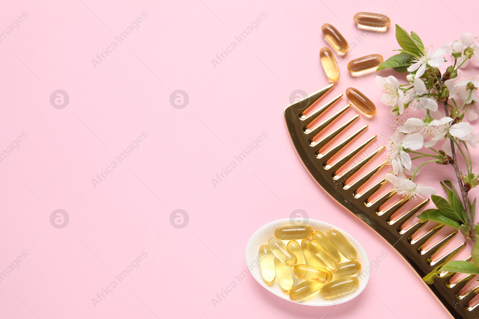 Collagen capsules, blossoms and comb on pink background, flat lay. Space for text Photo of Collagen capsules, blossoms and comb on pink background, flat lay. Space for text
