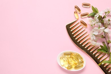 Photo of Collagen capsules, blossoms and comb on pink background, flat lay. Space for text