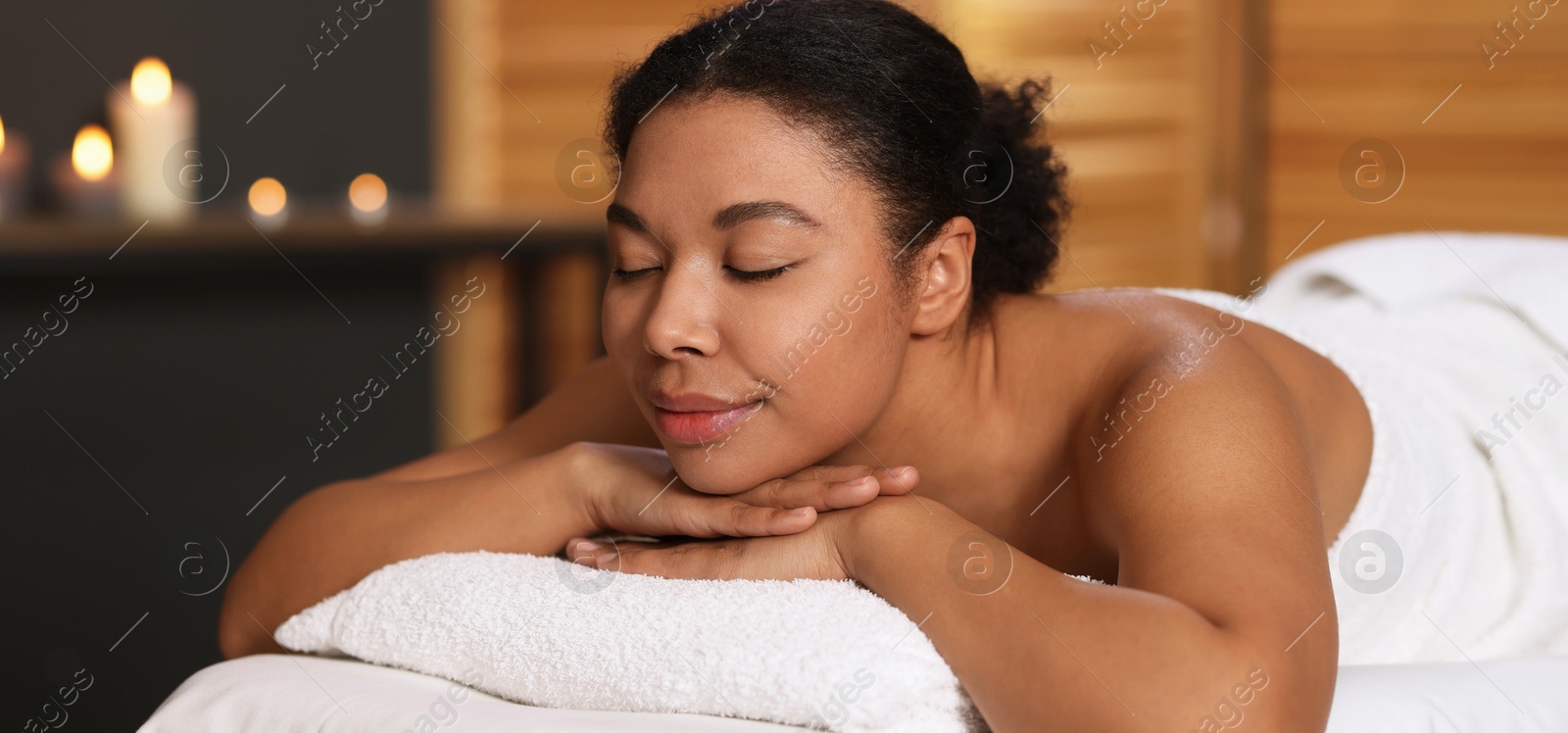 Photo of Beautiful woman relaxing on massage couch in spa salon