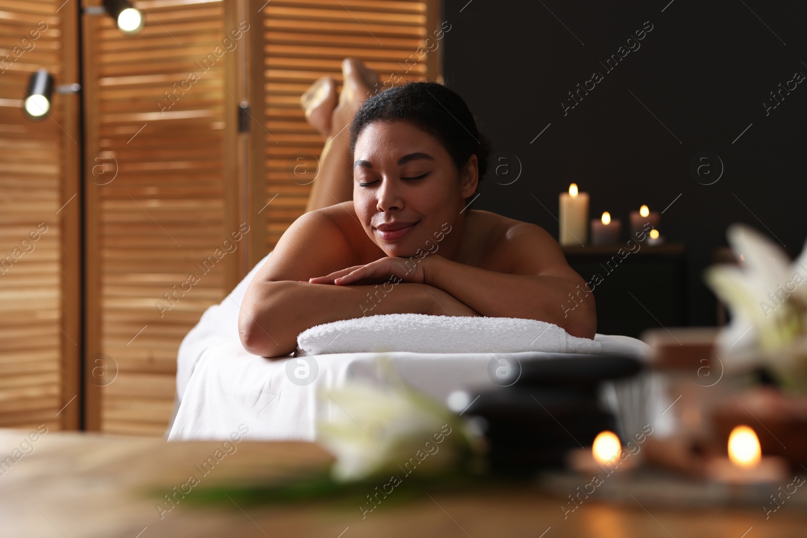 Beautiful woman relaxing on massage couch in spa salon Photo of Beautiful woman relaxing on massage couch in spa salon