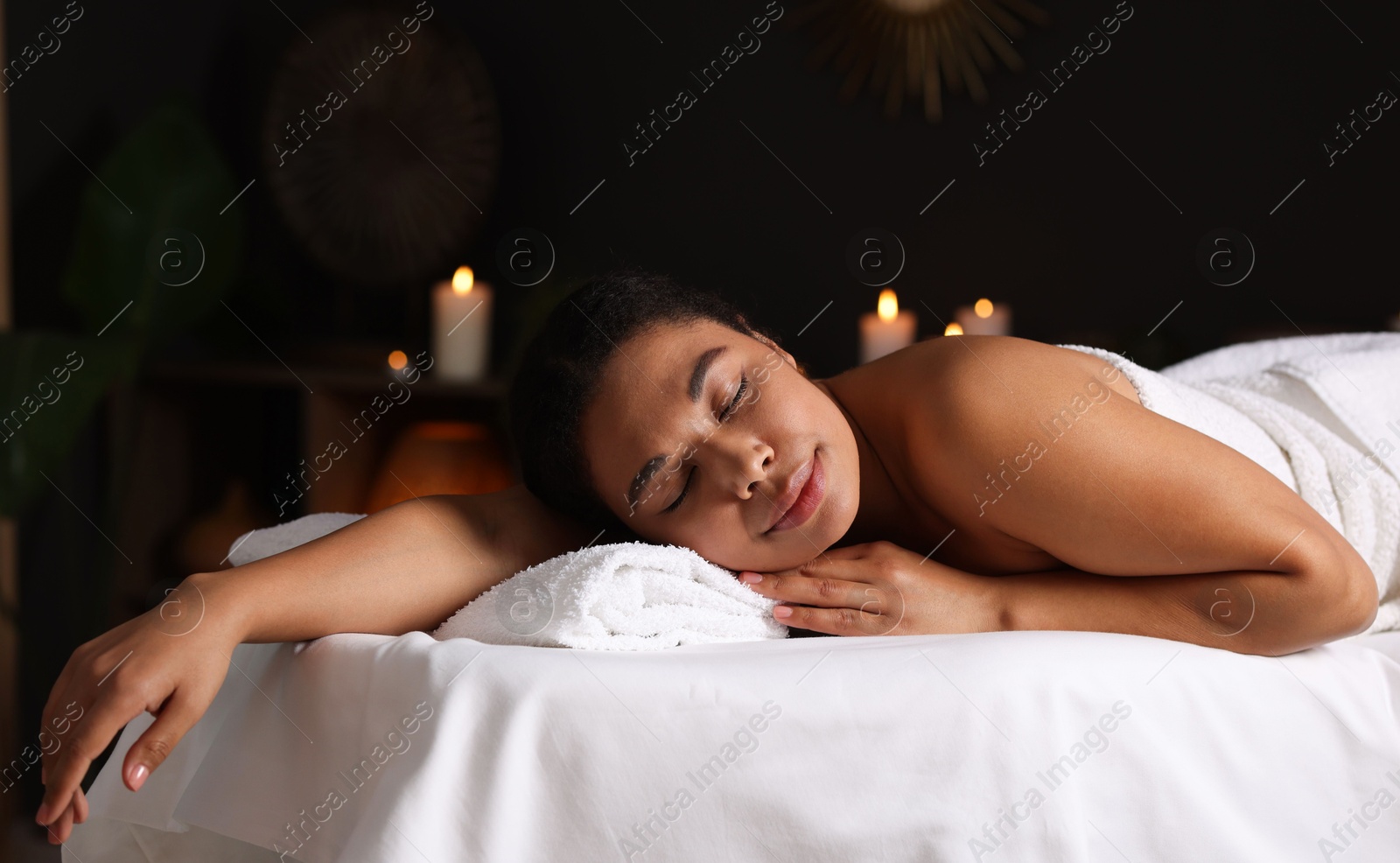 Beautiful woman relaxing on massage couch in spa salon Photo of Beautiful woman relaxing on massage couch in spa salon