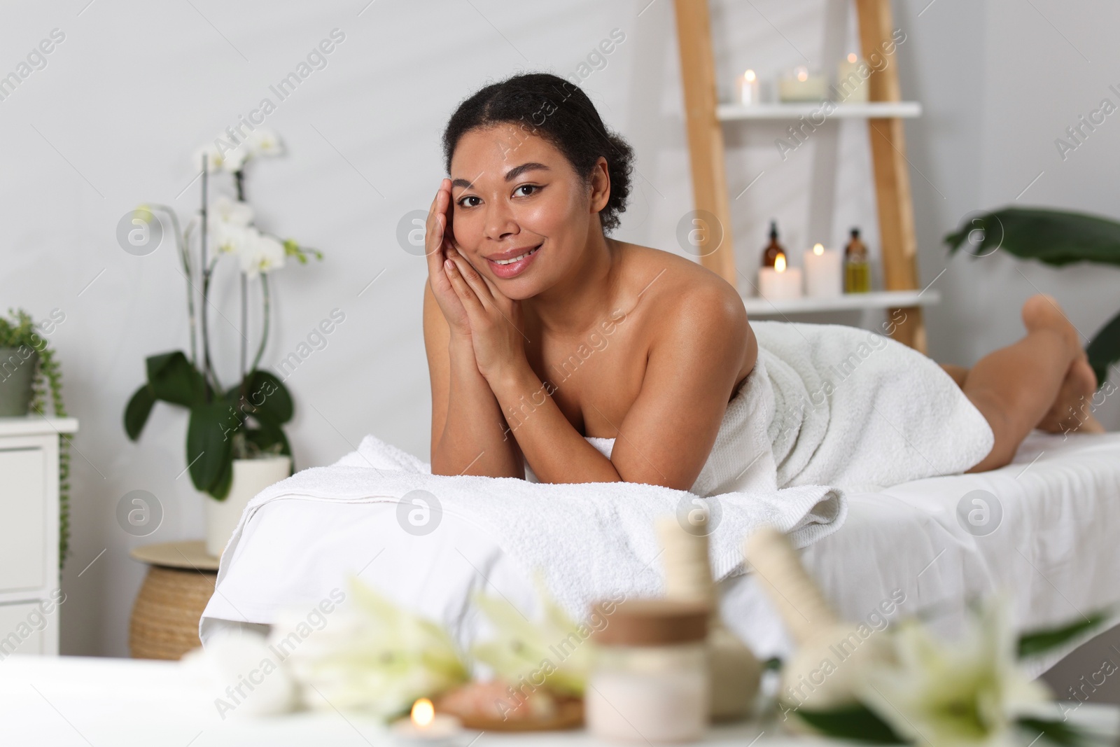 Beautiful woman relaxing on massage couch in spa salon Photo of Beautiful woman relaxing on massage couch in spa salon