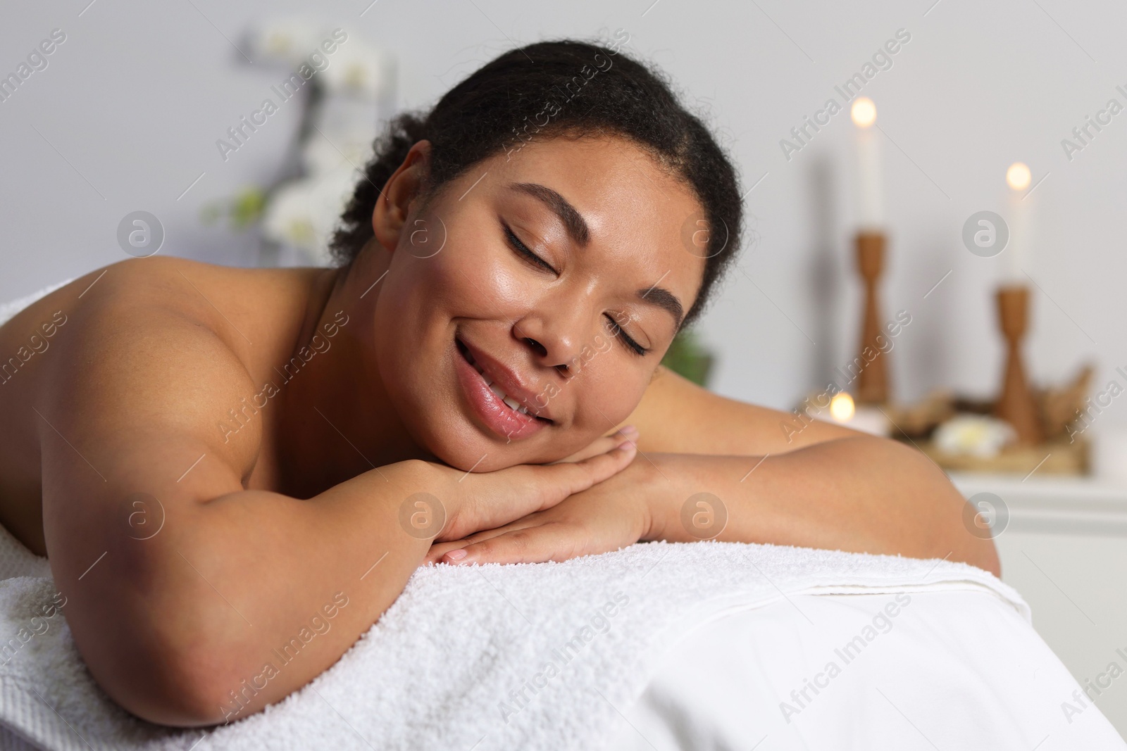 Photo of Beautiful woman relaxing on massage couch in spa salon
