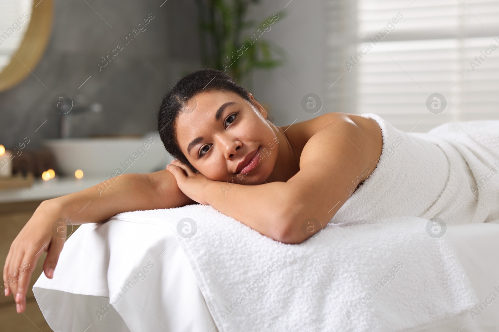 Beautiful woman relaxing on massage couch in spa salon Photo of Beautiful woman relaxing on massage couch in spa salon