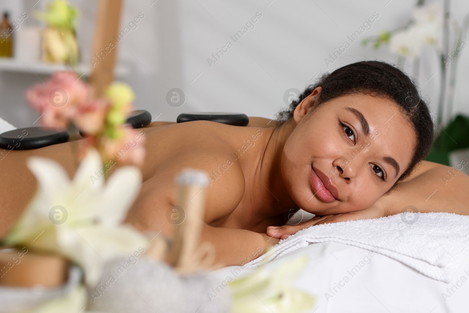Photo of Beautiful woman relaxing on massage couch in spa salon